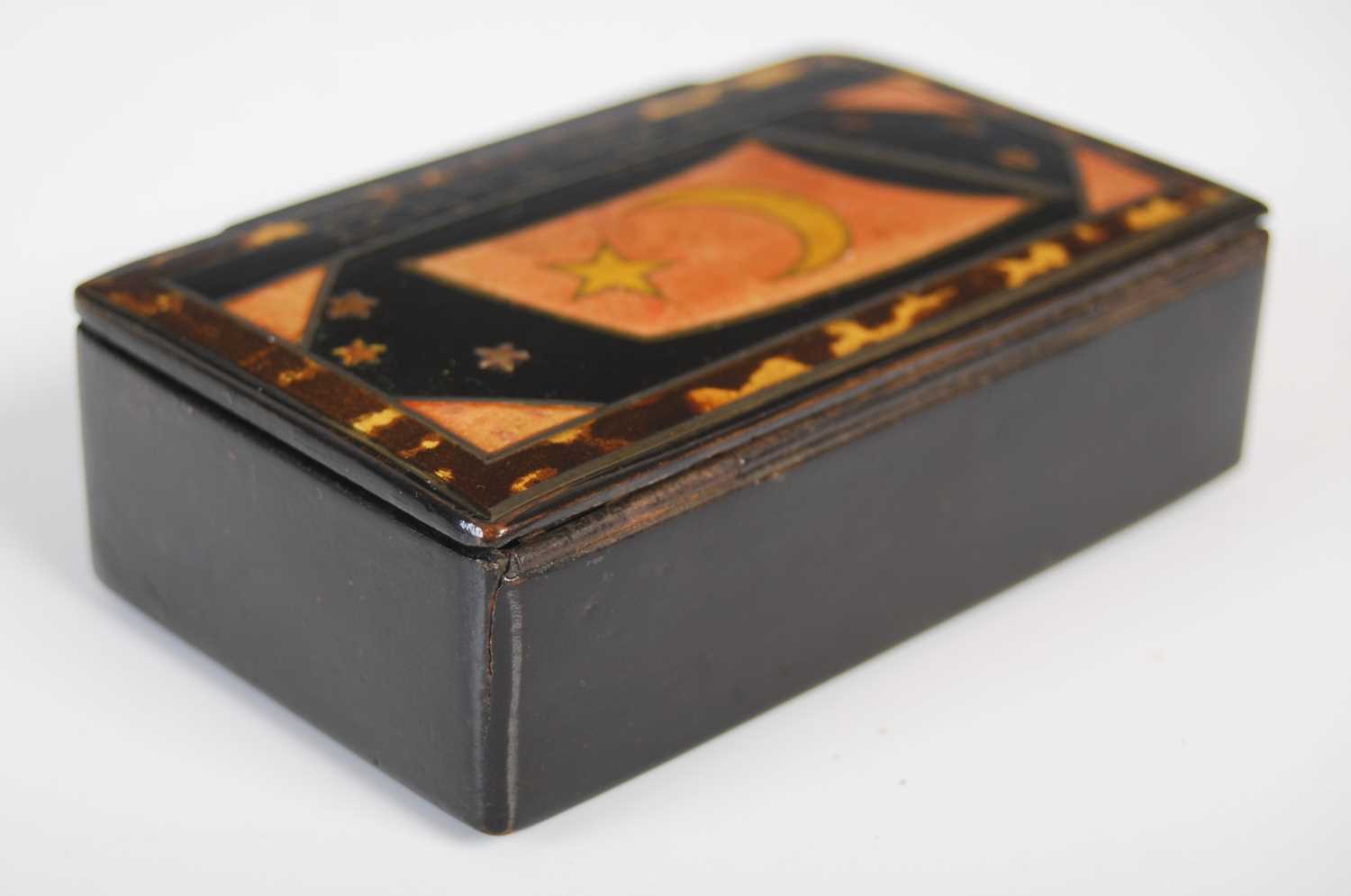 A black lacquer papier-mâché oblong snuff box, the hinged cover painted with a flag, star and - Image 2 of 4