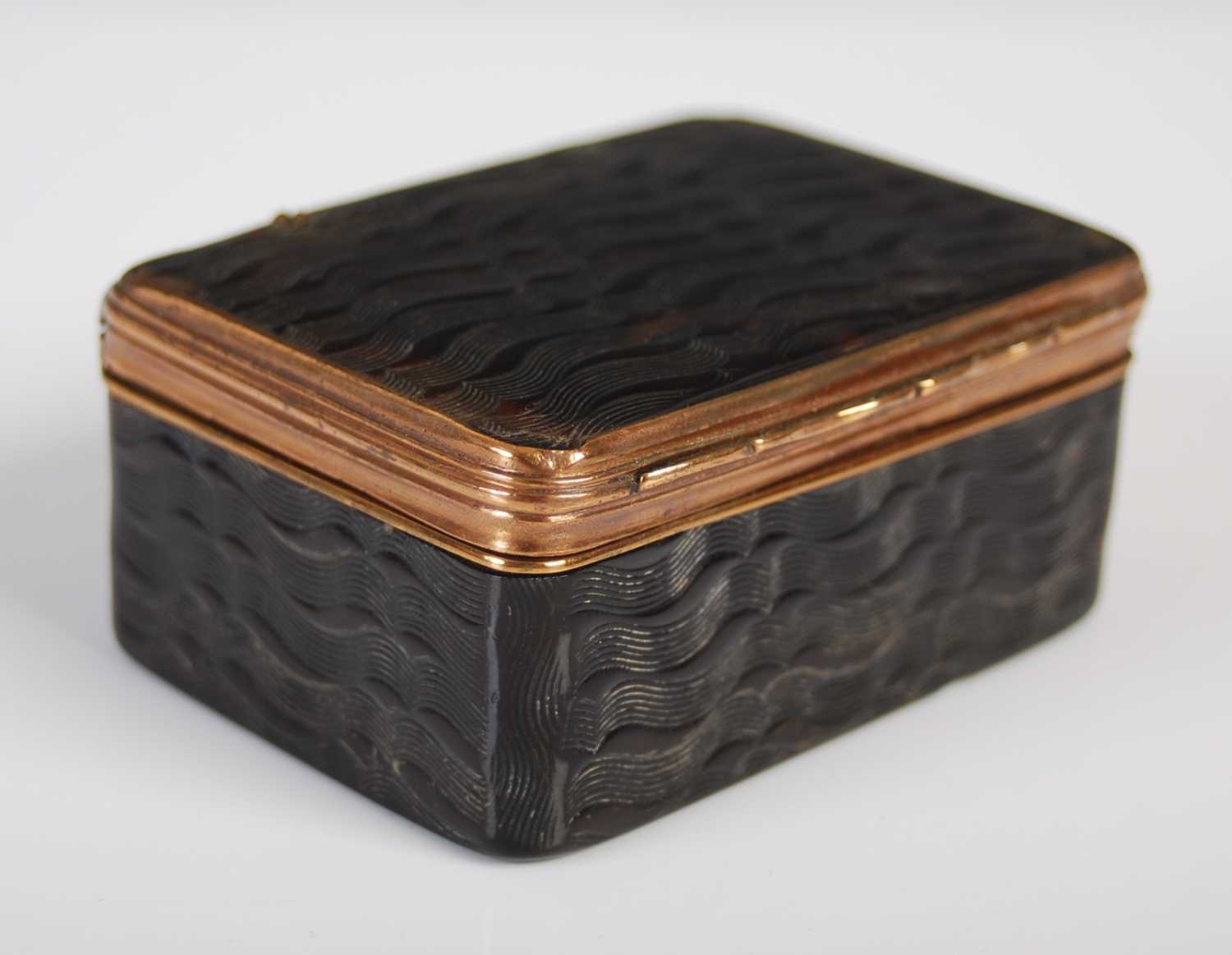 A tortoiseshell oblong snuff box with overall wave pattern design, with gilt-copper hinge, borders