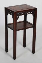 A Chinese dark wood urn stand, Qing Dynasty, the rectangular panel top above a pierced scroll carved