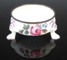 An 18th century Battersea enamel circular salt cellar, decorated with scattered foliate sprays