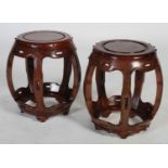 A pair of Chinese dark wood barrel-shaped stools, early 20th century, the circular panelled tops