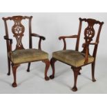 A pair of George III style mahogany elbow chairs, 20th century, the flower and scroll carved top