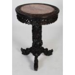 A Chinese dark wood occasional table, Qing Dynasty, the circular top centred with a mottled red