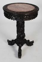 A Chinese dark wood occasional table, Qing Dynasty, the circular top centred with a mottled red