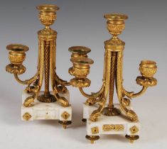 A pair of late 19th / early 20th century French gilt metal and white marble three light