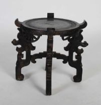 A Chinese ebonised urn stand, early 20th century, the dished circular top raised on four archaic