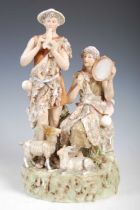 A Royal Dux porcelain figure group modelled with male and female musicians playing the pipes and