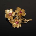 An 18ct gold and synthetic ruby flower brooch, stamped marks, 43.4mm long, gross weight 8.4 grams.