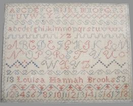 A Victorian needlework sampler by Louisa Hannah Brooks dated 1853, worked in red and blue coloured