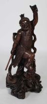 A Chinese carved dark wood figure of a warrior and dragon, late 19th/ early 20th century, the eyes