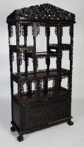 A late 19th century Chinese dark wood open display cabinet, with carved and pierced surmount of