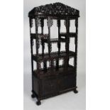 A late 19th century Chinese dark wood open display cabinet, with carved and pierced surmount of