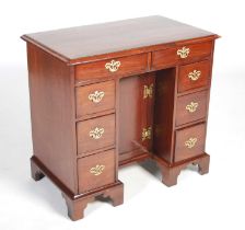 A George II red walnut kneehole desk, the rectangular top with moulded edge above two cockbeaded