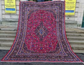 A Persian Mashad carpet, 20th century, the rectangular magenta ground centred with a blue lozenge