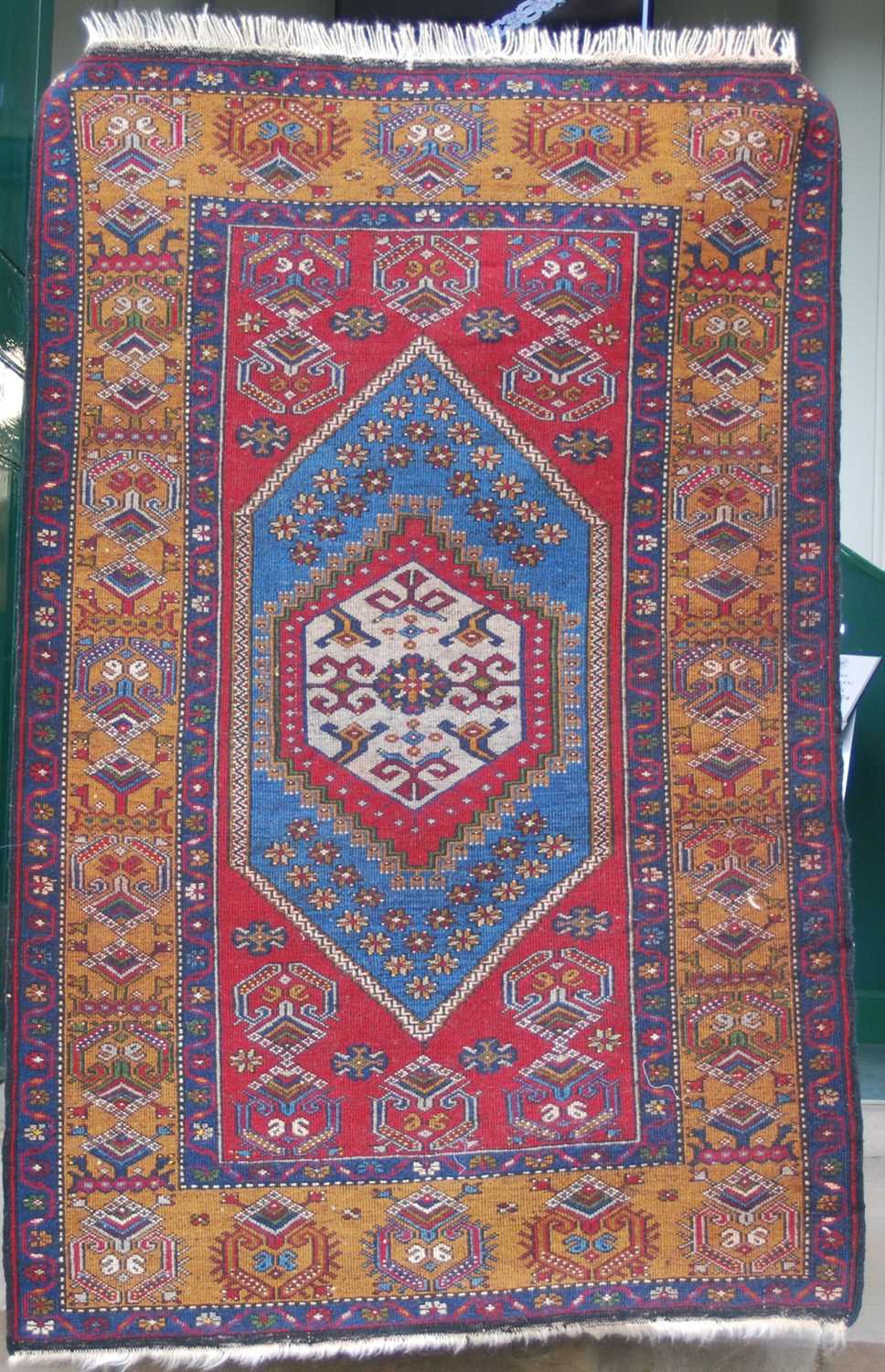A Turkish rug, 20th century, the rectangular madder ground centred with a blue ground lozenge - Image 2 of 4