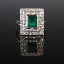A mid 20th century white metal, emerald and diamond cluster ring, centred with a rectangular