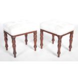 A pair of George III mahogany rectangular stools, the upholstered seats raised on four baluster