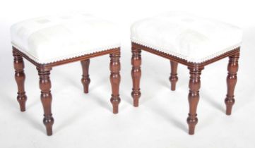 A pair of George III mahogany rectangular stools, the upholstered seats raised on four baluster
