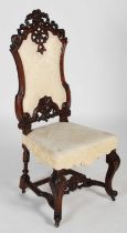 A 19th century carved walnut hall chair, the upright back with foliate and scroll carved surmount