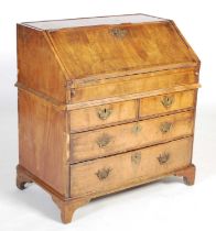 A George II walnut bureau, the rectangular fall-front opening and resting on loppers, to a fitted