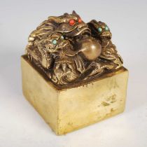 A Chinese gilt metal seal, early 20th century, modelled with three dragons and a flaming pearl,