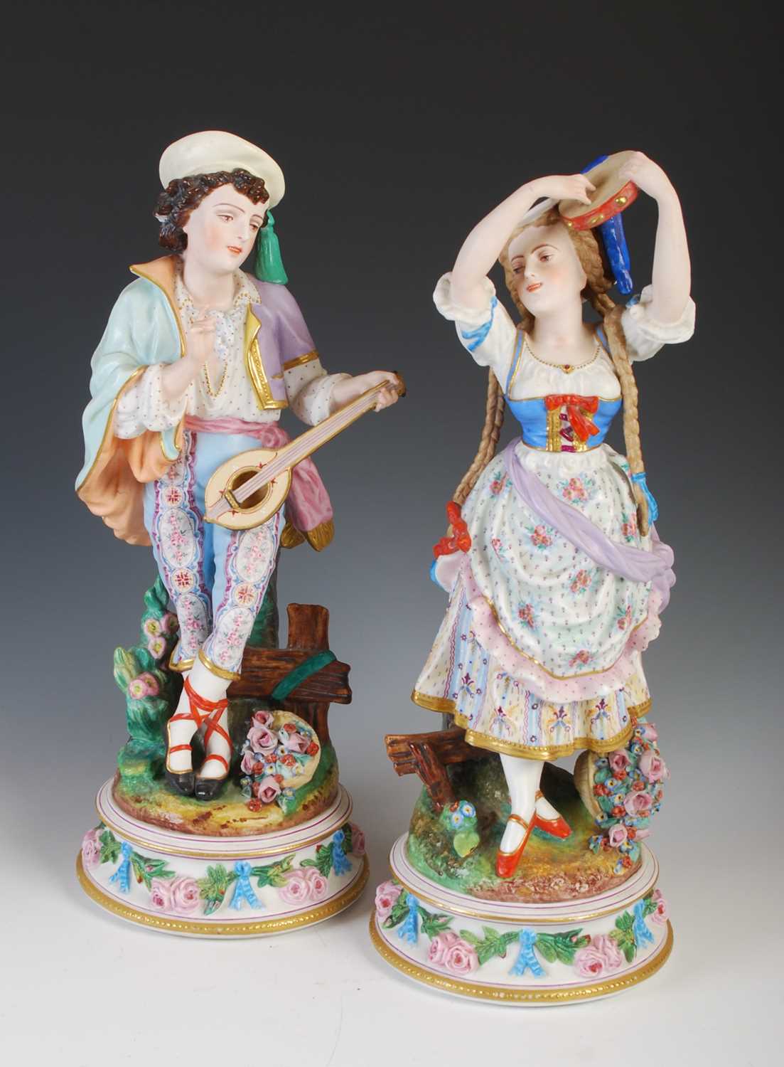 A pair of late 19th century French Bisque porcelain figures, modelled as a boy playing the