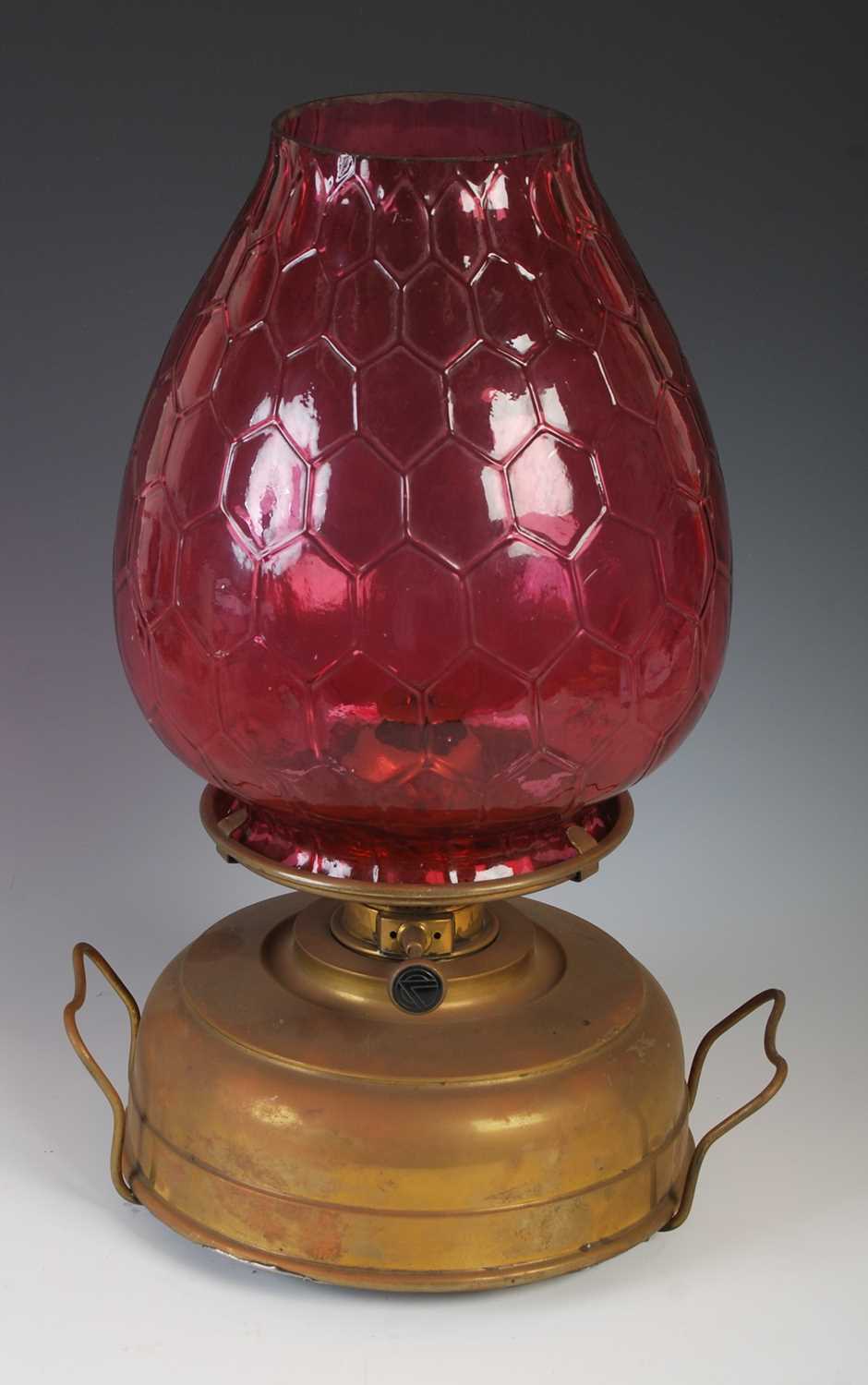 A late 19th century brass oil burning paraffin lamp, with ruby glass shade, 42.5cm high.