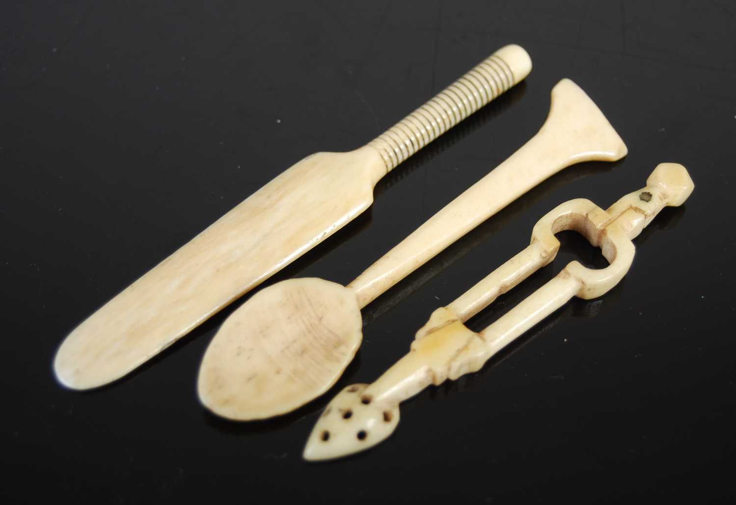 Three Scottish bone snuff spoons, comprising one carved as a pair of fire tongs with pierced pointed