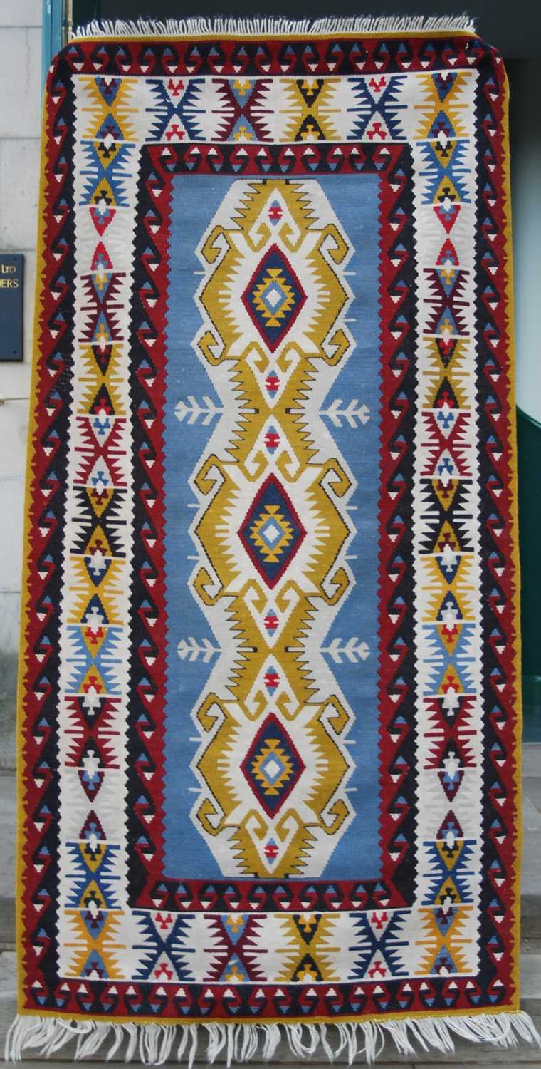 A Kelim rug, 20th century, the rectangular blue ground centred with a row of three lozenge shaped - Image 2 of 5