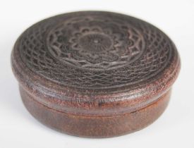 A pressed leather circular snuff box, the detachable cover and base with central rosette and