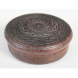 A pressed leather circular snuff box, the detachable cover and base with central rosette and