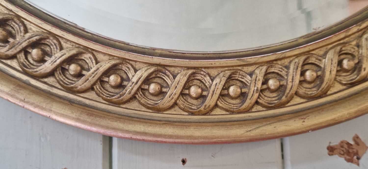 A late 19th / early 20th century gilt framed oval bevelled wall mirror, 84.5cm x 60cm. - Image 2 of 2