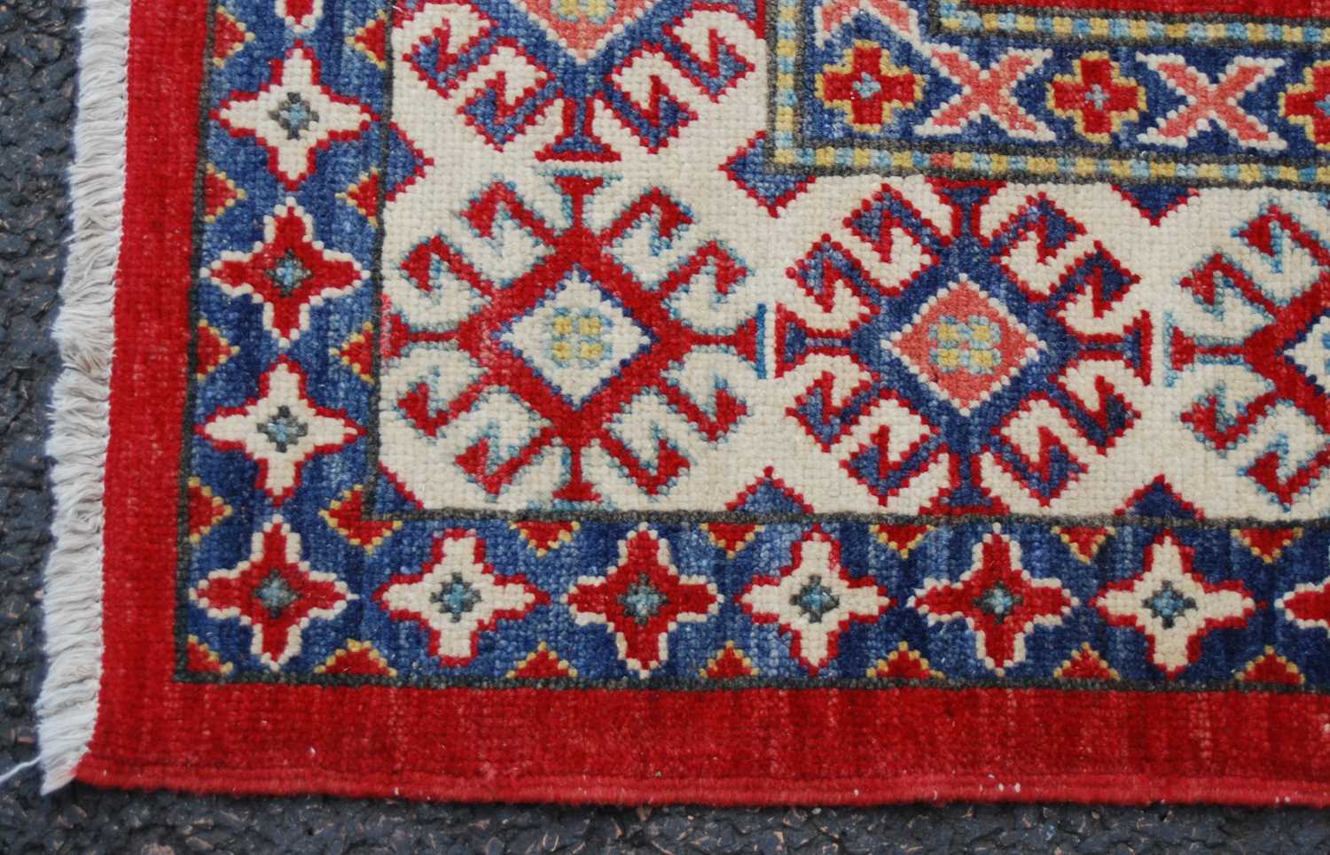 An Afghan Kazak rug, 20th century, the rectangular madder ground centred with a large blue ground - Image 3 of 5