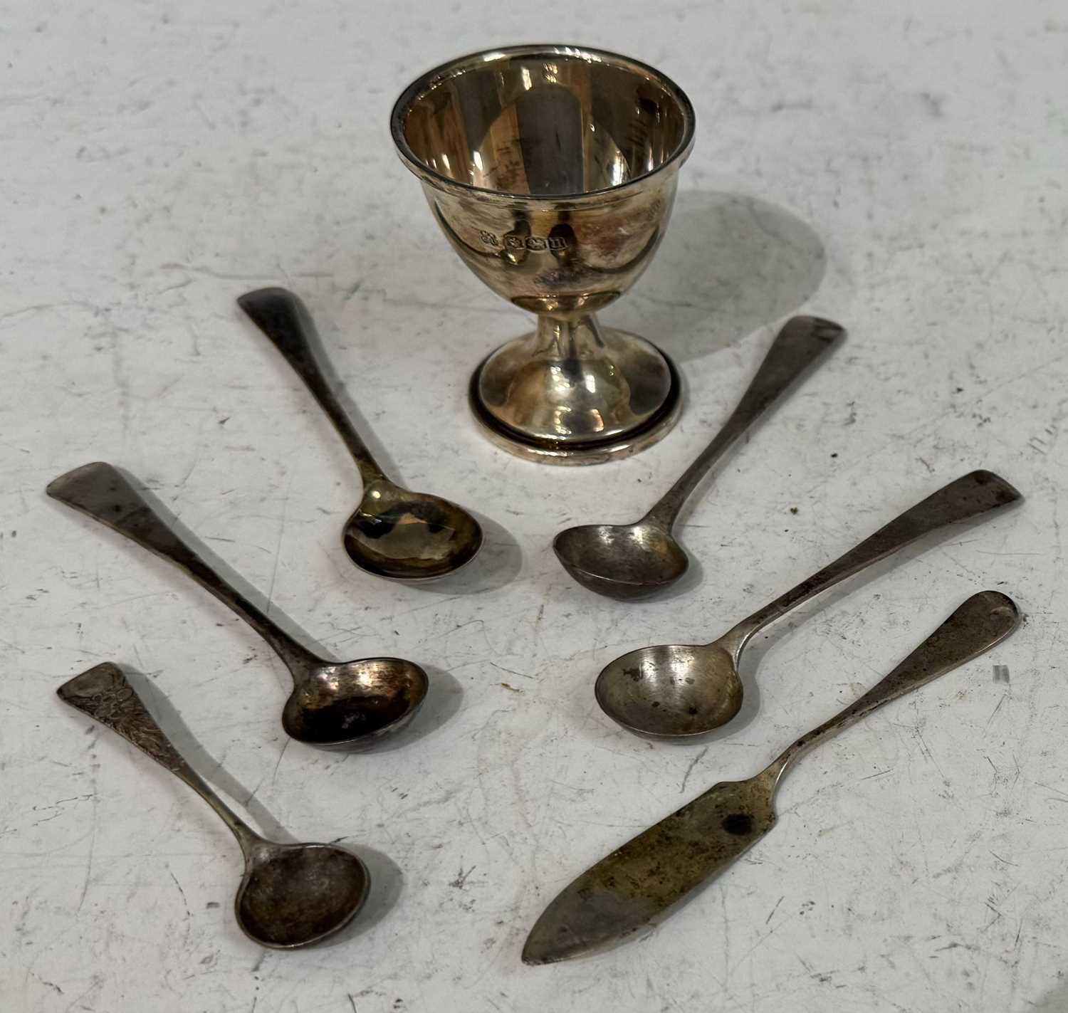 A Birmingham silver egg cup and spoon, together with four assorted salt spoons and butter knife.