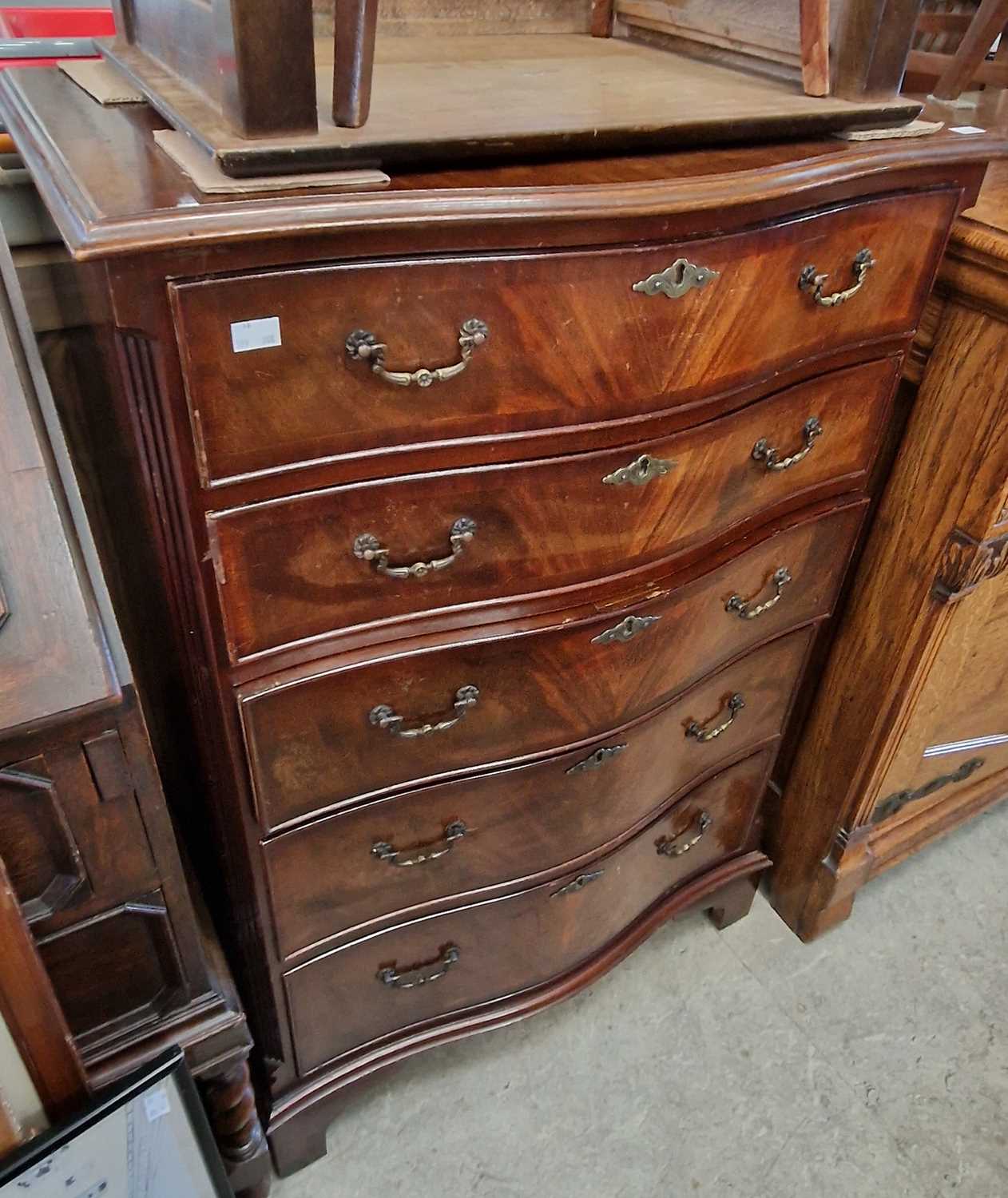 A reproduction mahogany serpentine front chest of five drawers, 70.5cm wide x 106cm high.