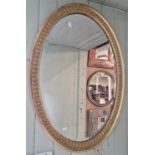 A late 19th / early 20th century gilt framed oval bevelled wall mirror, 84.5cm x 60cm.