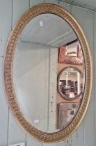 A late 19th / early 20th century gilt framed oval bevelled wall mirror, 84.5cm x 60cm.