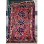 A Persian rug, 20th century, the rectangular field centered with three blue ground lozenge shaped