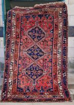 A Persian rug, 20th century, the rectangular field centered with three blue ground lozenge shaped