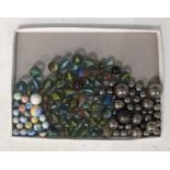 A collection of vintage marbles, to include 'Steelies', 'Cats eyes', and 'Milk glass' examples in