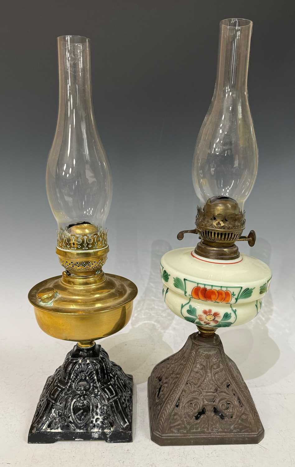 An early 20th century oil lamp, with twin 'Duplex' burner adjusters, above an opaque green glass