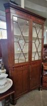 A 19th century mahogany two part corner cupboard, the upper section with astragal glazed doors