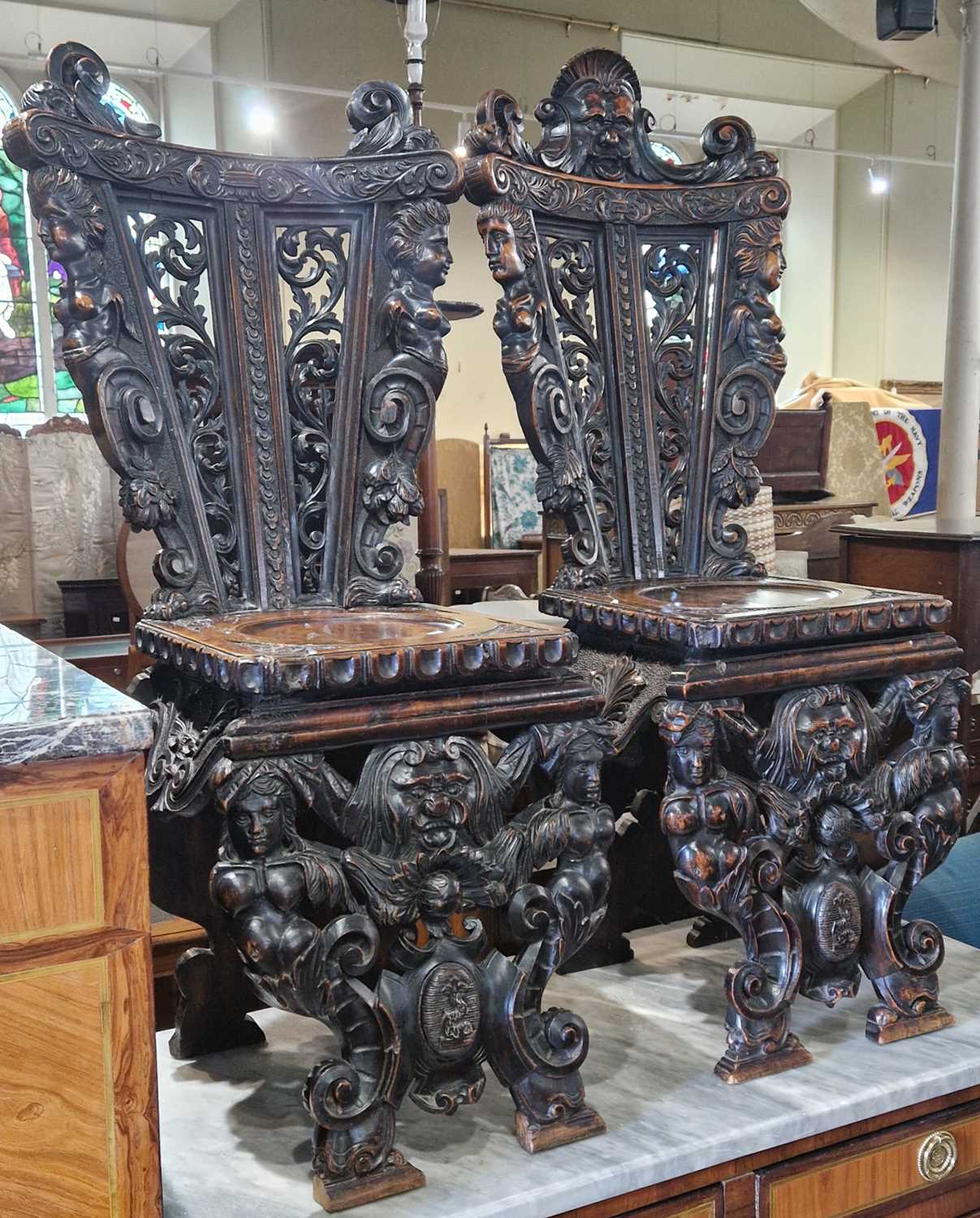 A pair of 19th century Italian Renaissance style stained wood, probably walnut, Sgabello hall chairs