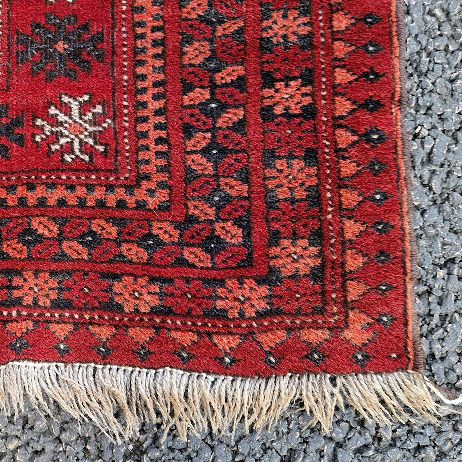 A Persian Tekke rug, the rectangular madder ground centred with two rows of twenty octagonal - Image 3 of 4