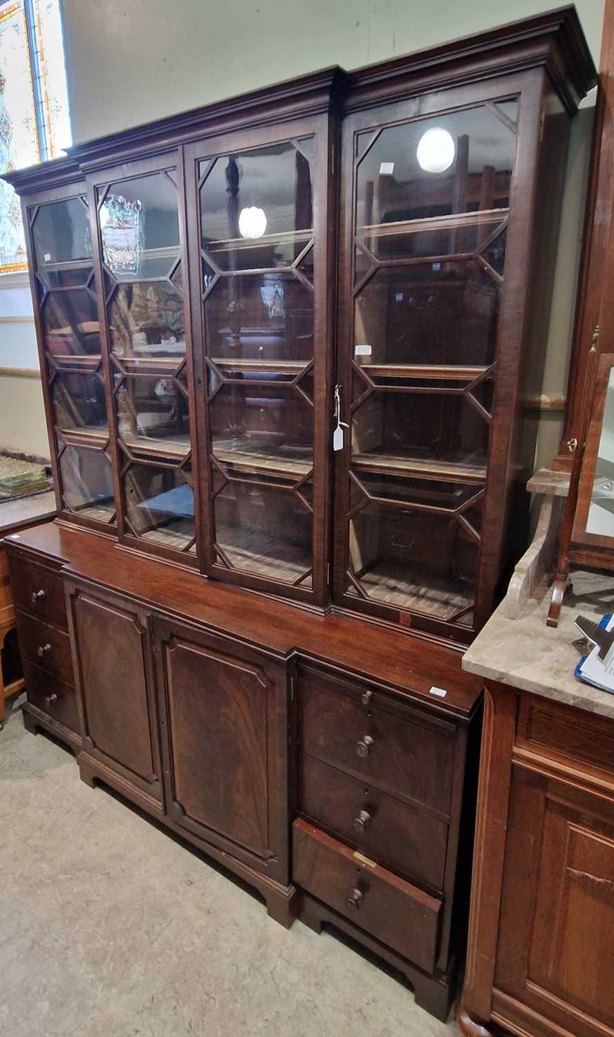 A reproduction mahogany breakfront bookcase, with moulded cornice over four glazed cupboard doors,