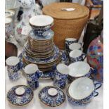 A Chinese porcelain blue and white part tea set with gilded borders, the teapot contained within a