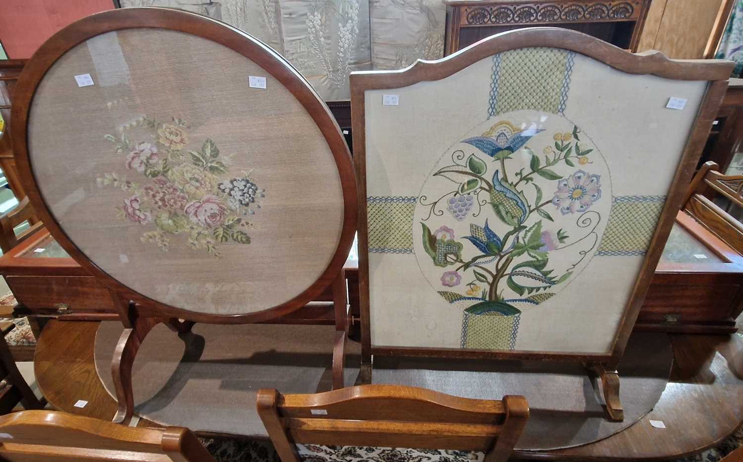 A vintage needlework upholstered fire screen, together with a needlework upholstered circular fire