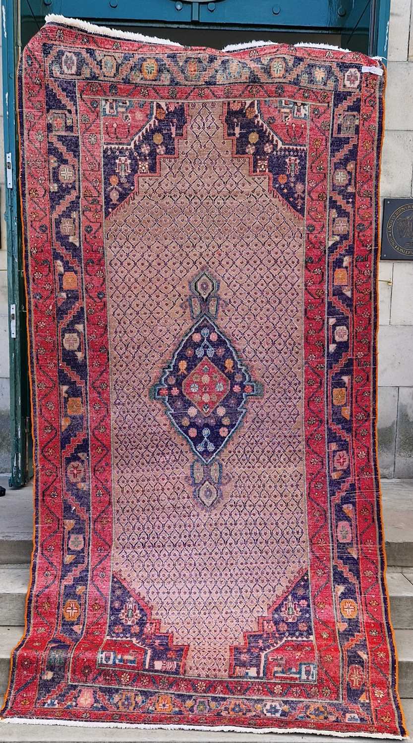 A Persian rug, 20th century, the rectangular cafe au lait coloured ground centred with a blue floral - Image 2 of 4