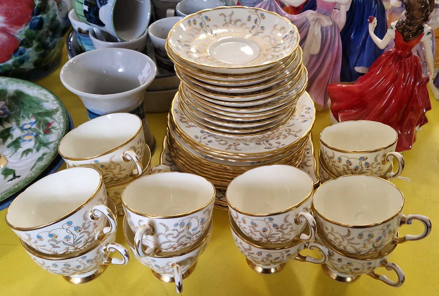 A vintage plant Tuscan China yellow ground twelve piece tea set decorated with gilded blue and