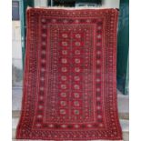 A Persian Tekke rug, the rectangular madder ground centred with two rows of twenty octagonal